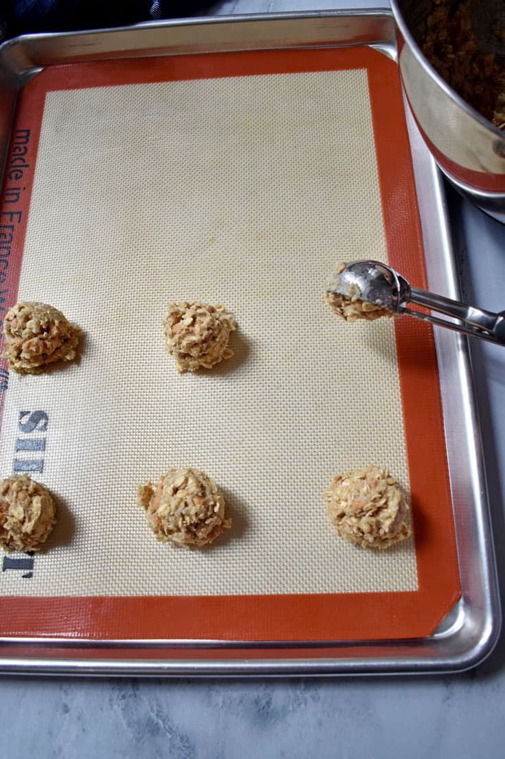 Toasted Coconut Butterscotch Oatmeal Cookies dough scoops on silicone lined baking pan