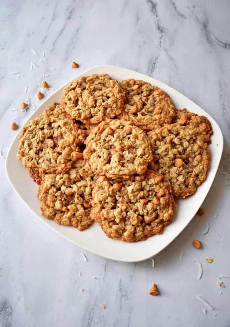 Stack of Toasted Coconut Butterscotch Oatmeal Cookies on white plate