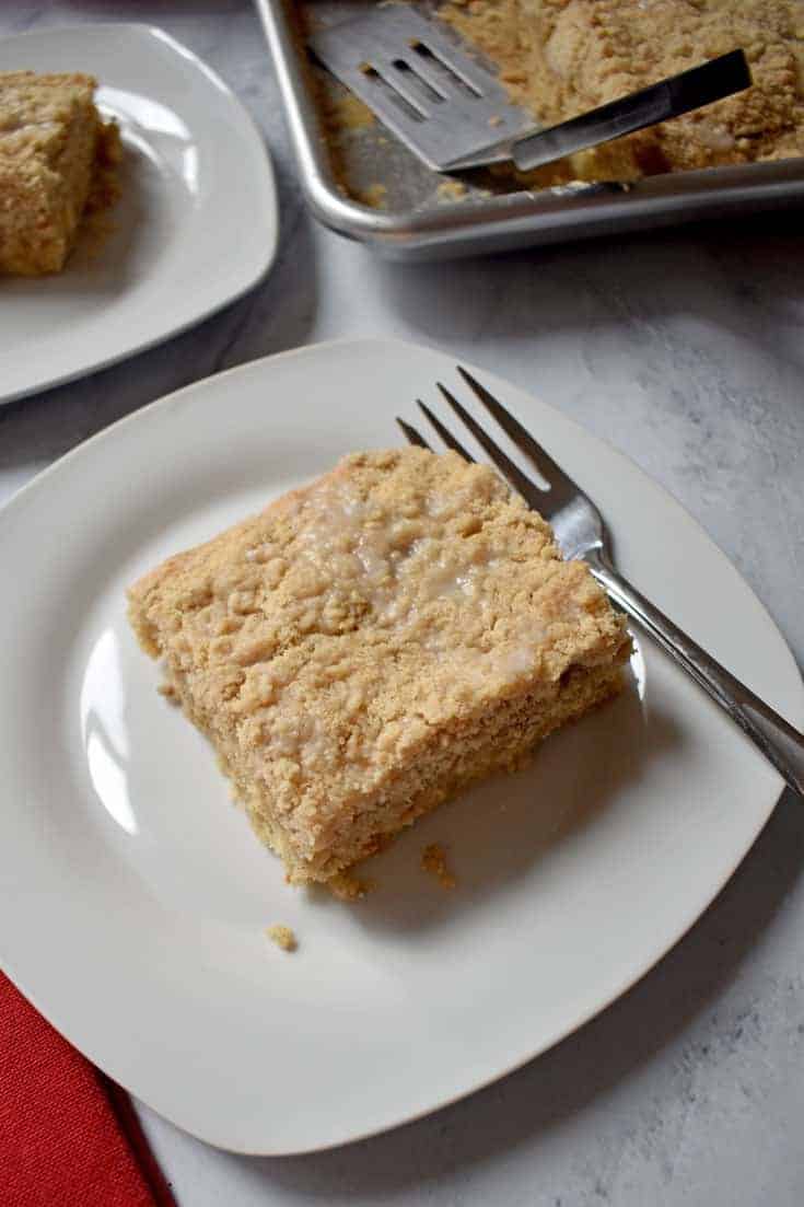 Piece of Apple Walnut Crumb Cake {Gluten Free} on white plate with sheet pan of cake in upper right corner and piece of cake on white plate in upper left corner | Flavor Walk
