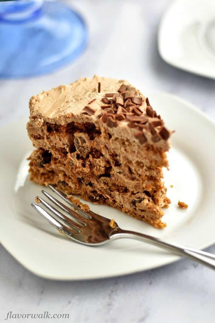 Close-up of slice of chocolate icebox cake with fork on white plate,