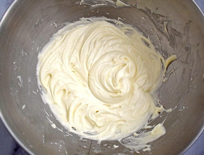 Overhead view of cream cheese frosting in large mixing bowl