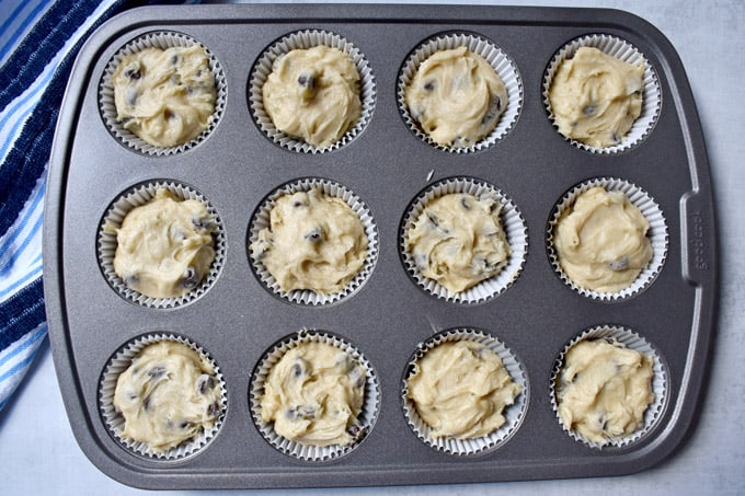 Overhead view of gluten free chocolate chip muffins batter in baking cups in muffin pan