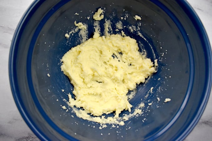 Overhead view of blue mixing bowl with butter and sugar creamed together.