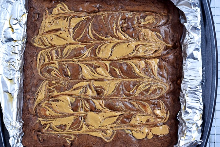 Overhead view of baked gluten free peanut butter brownies in foiled lined pan