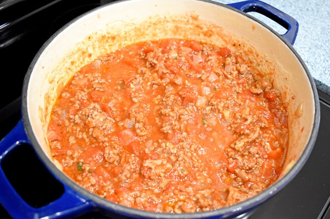 Overhead view of Dutch oven filled with meat sauce for easy gluten free lasagna.