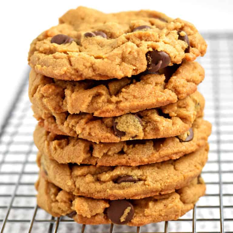 A stack of gluten free peanut butter chocolate chip cookies on a wire rack.