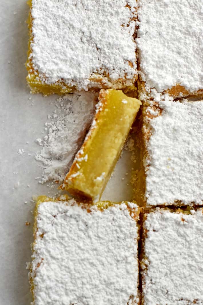 Overhead view of 6 gluten free lemon bars with the left middle bar turned on its side.