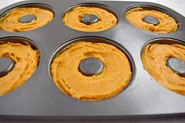 Donut pan filled with batter for gluten free pumpkin donuts.