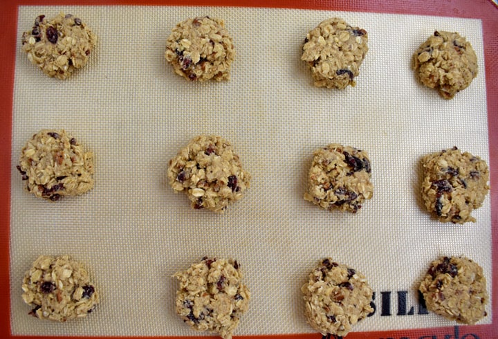 Overhead view of gluten free cranberry oatmeal cookie dough balls on a silicone liner.