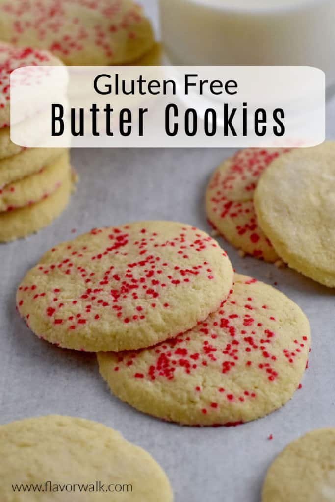 Pinterest pin with gluten free butter cookies scattered on parchment paper, a glass of milk in the background, and a black and white text overlay near the top.