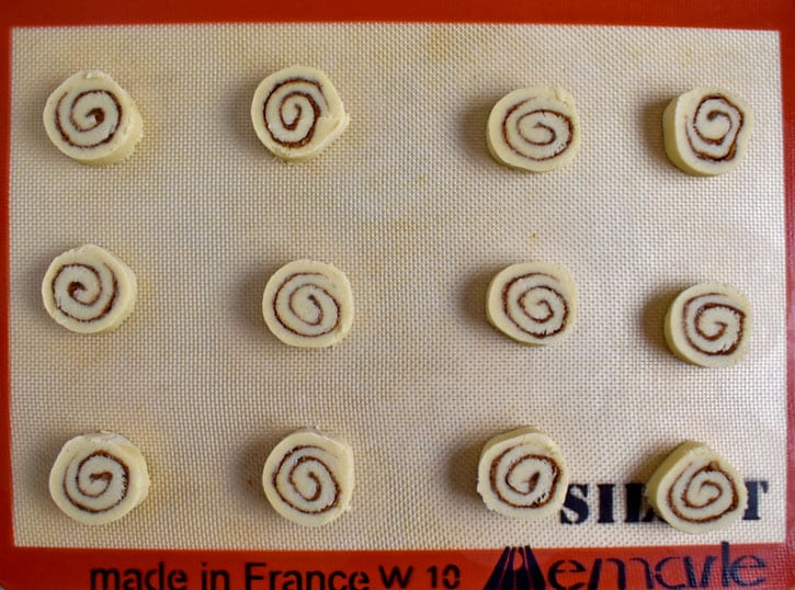 Overhead view of unbaked gf cinnamon roll cookies on silicone liner.