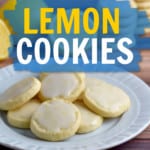 A small round plate filled with glazed gluten free lemon cookies with lemons and stacks of more cookies in the background. A blue text overlay with white text at the top of the image and a blue text overlay with yellow and white text near the middle of the image.