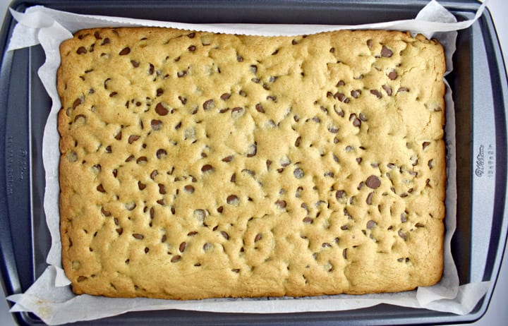 Overhead view of baked gf chocolate chip cookies bars in pan.