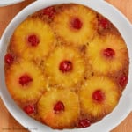 Overhead view of gluten free pineapple upside-down cake on round white plate.