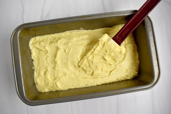 Overhead view of gf lemon pound cake batter and rubber spatula in loaf pan.