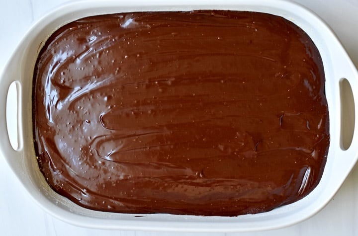 Overhead view of frosted gluten free zucchini brownies in a white 9x13-inch baking pan.