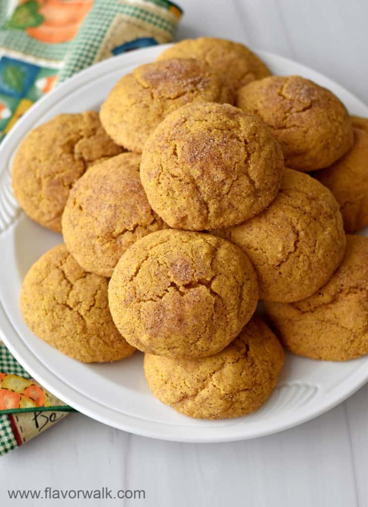 Close up view of a plateful of gluten free pumpkin snickerdoodles with a multi-colored cloth napkin on the left.