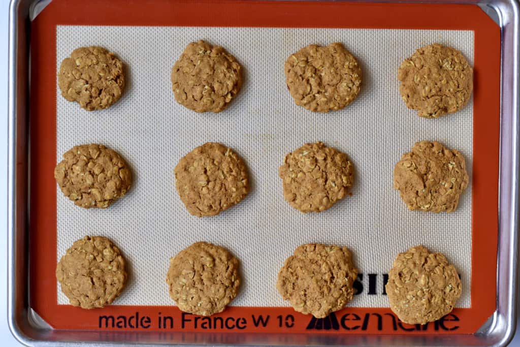Overhead view of Silpat lined baking pan containing 12 gluten free pumpkin oatmeal cookies.