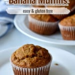 Close up of one gluten free pumpkin banana muffin on small plate with more muffins in the background. Text overlay near top of image for Pinterest.