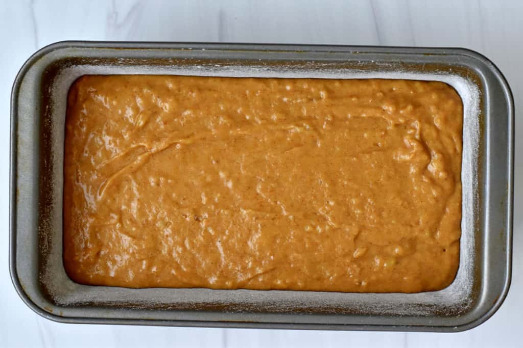 Overhead view of gluten free pumpkin banana bread batter in loaf pan.