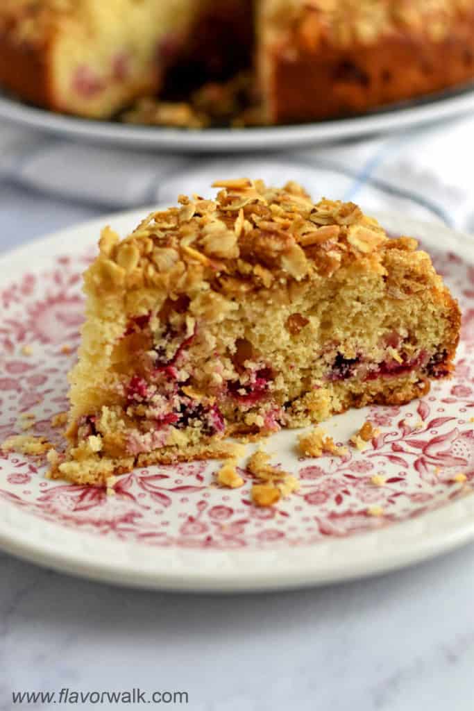 A slice of gluten free cranberry cake on a white and pink floral plate.