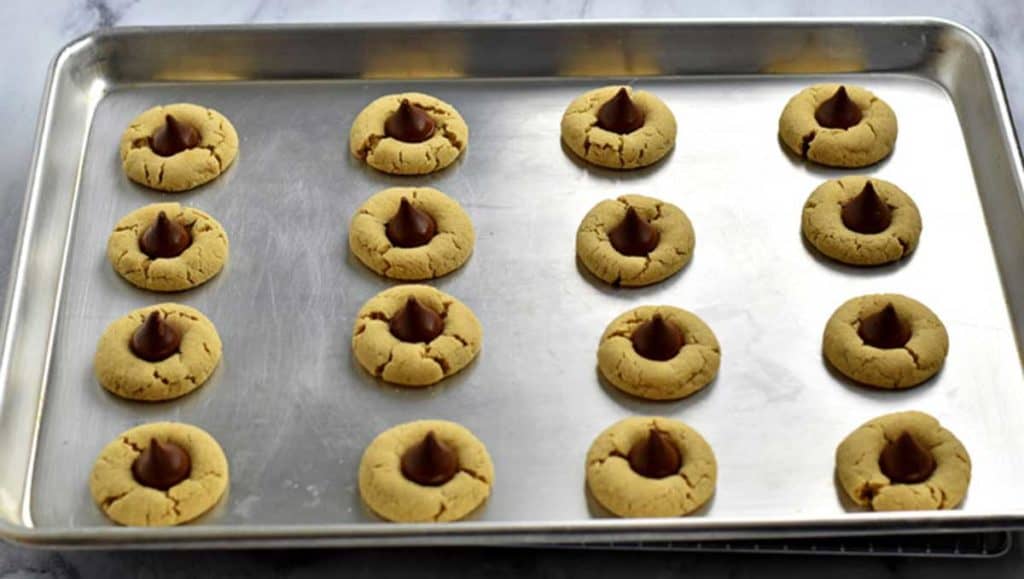 Baking pan filled with gluten free peanut butter blossom cookies.