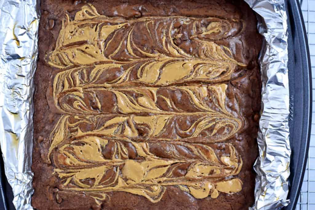 Overhead view of baked peanut butter brownies in foil-lined pan.