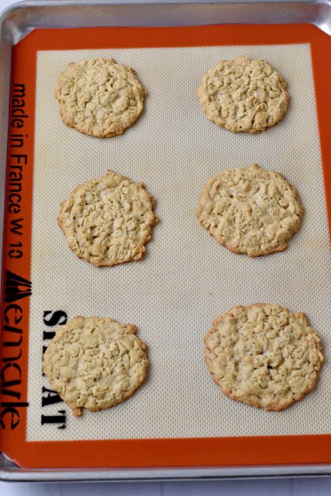 Silpat lined baking pan with just baked peanut butter oatmeal cookies.