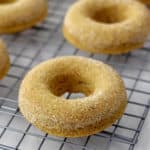 Close-up view of baked gluten free cinnamon sugar donuts on wire rack.