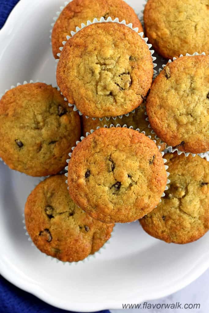 Overhead view of a stack of gluten free chocolate chip banana muffins on a white serving plate.