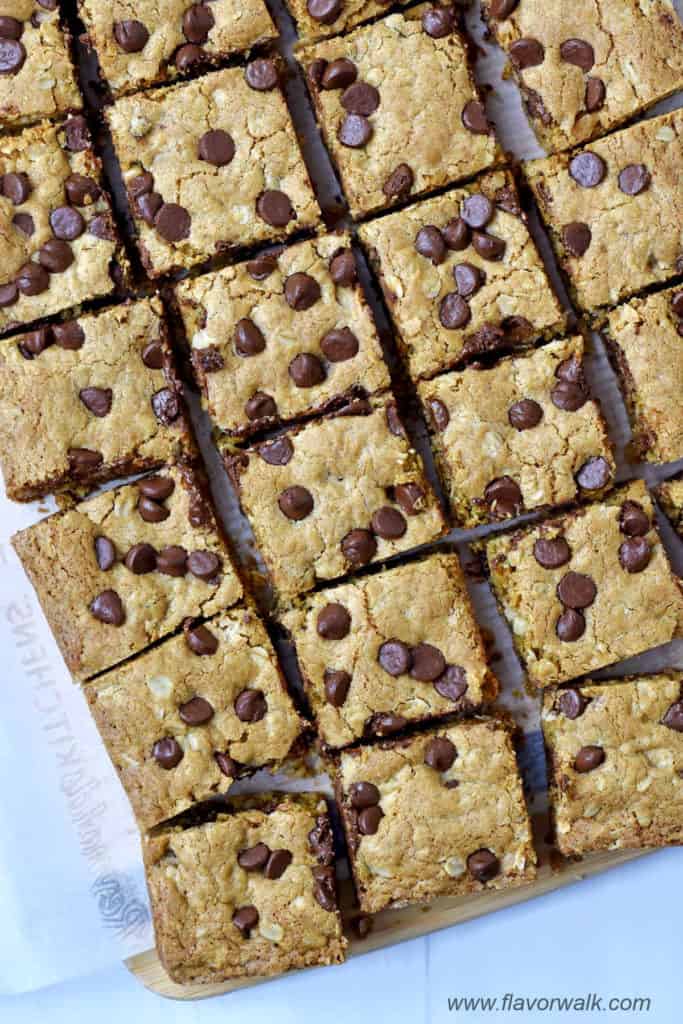 Overhead view of cut oatmeal chocolate chip bars on a parchment-lined cutting board.