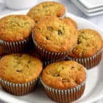 White serving plate filled with gluten free banana and chocolate chip muffins.