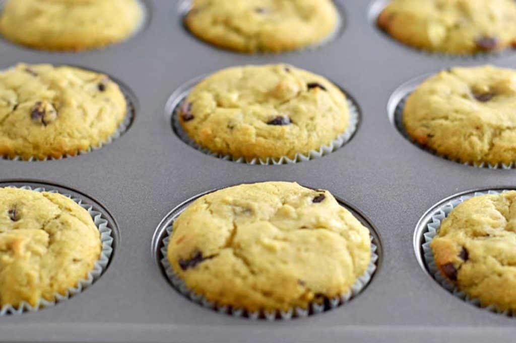 Baked gluten free chocolate chip banana muffins in lined muffin pan.