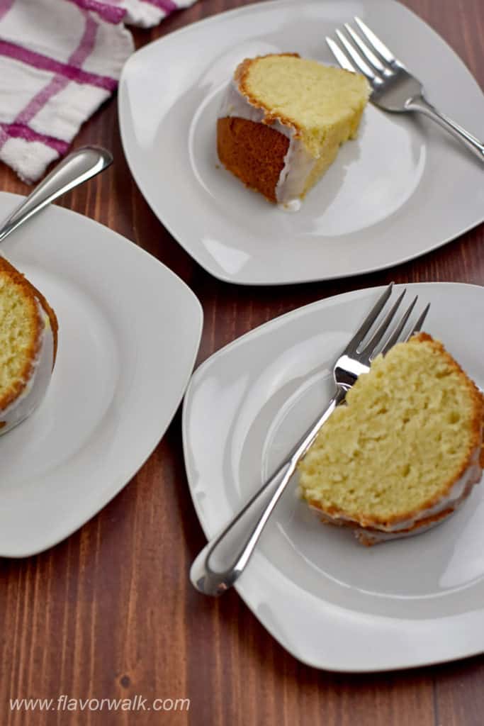 Three slices of gluten free lemon cake and forks on individual serving plates.