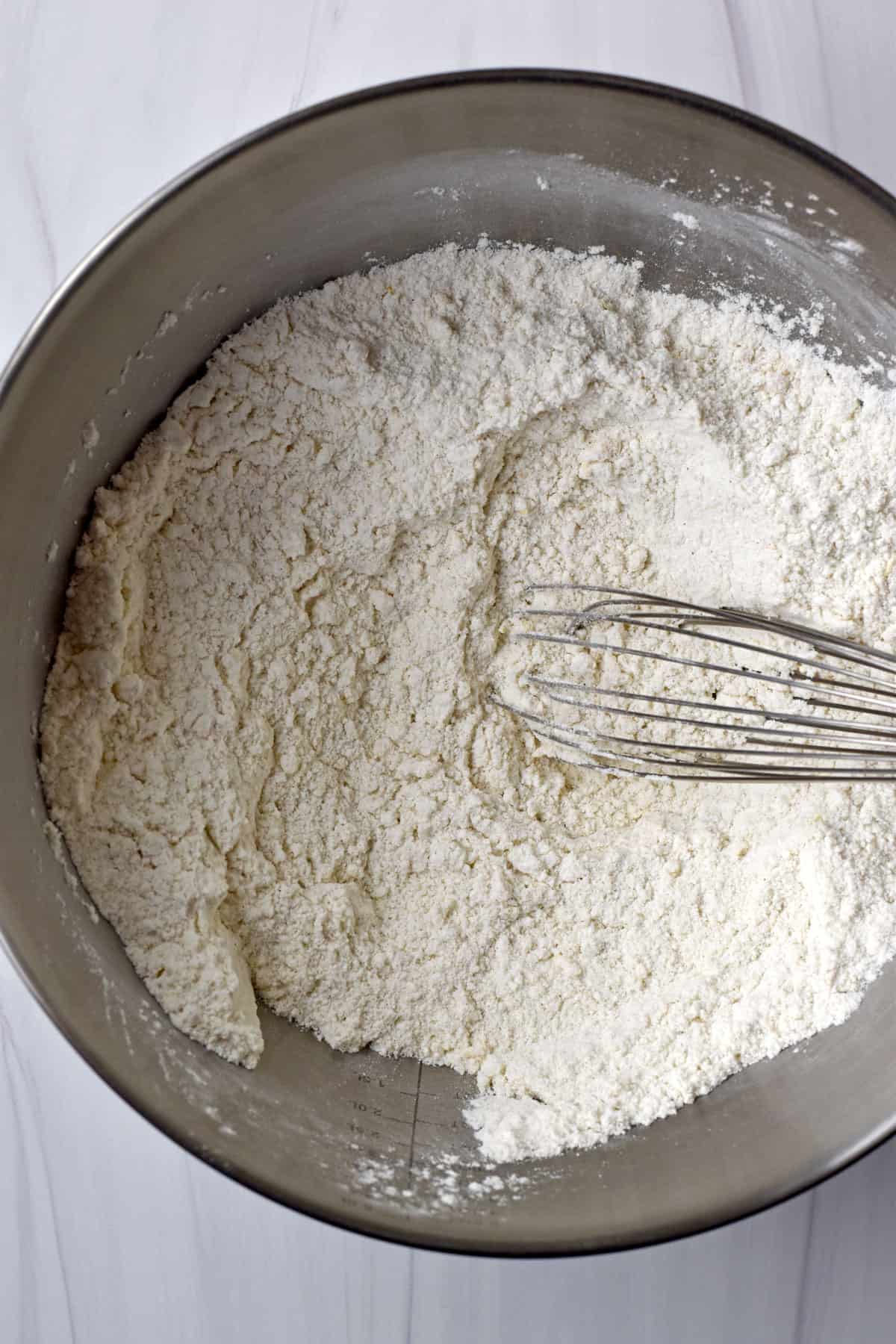 Gluten free flour blend, sugar, baking powder, salt, and orange zest whisked together in large metal mixing bowl.