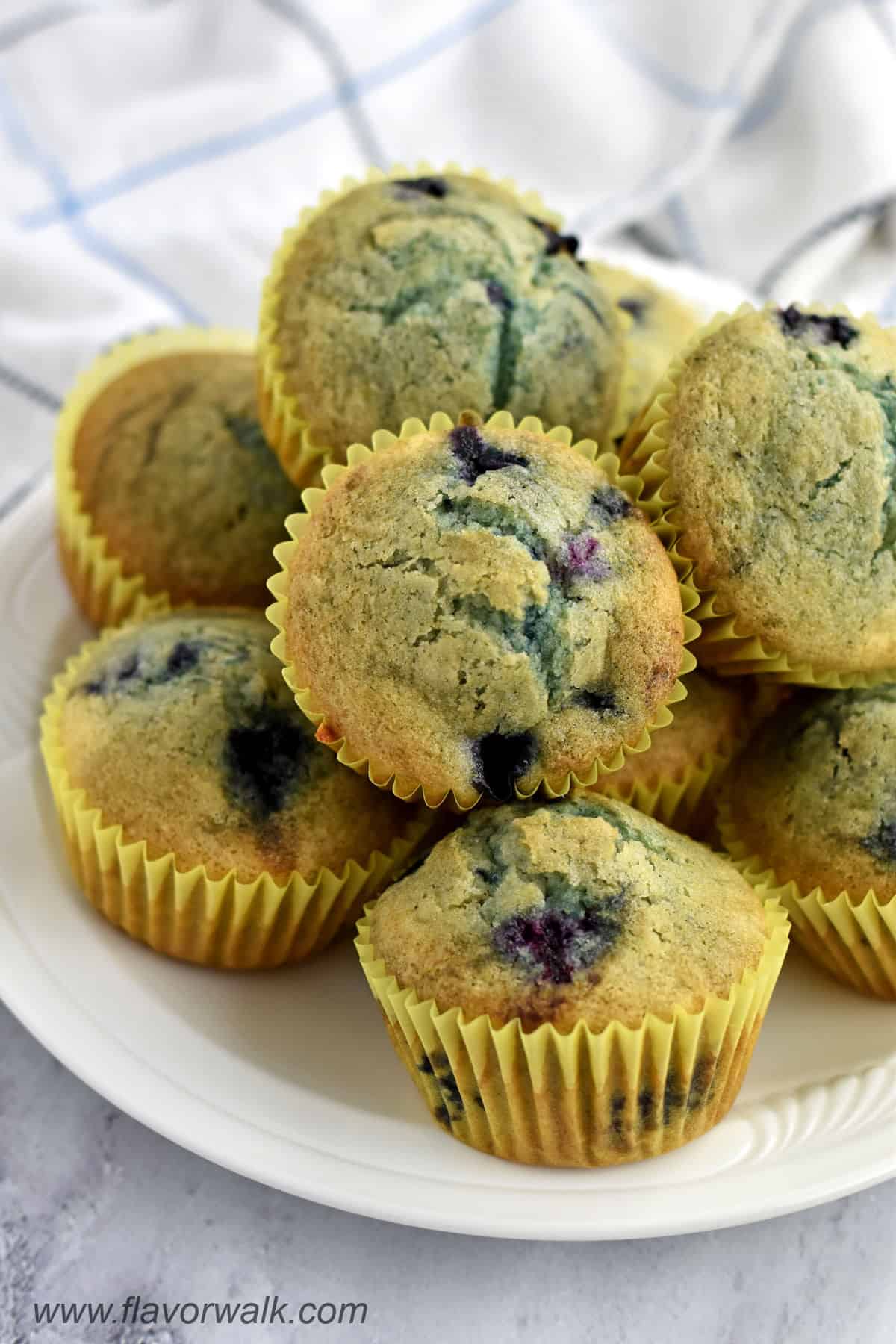 A stack of gluten free blueberry muffins on a white plate.