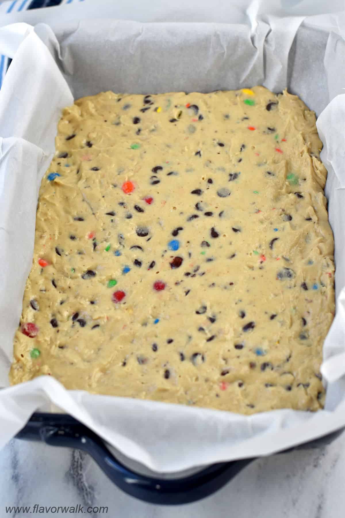 Cookie dough for no bake cookie dough bites in a 9x13-inch parchment-lined pan.