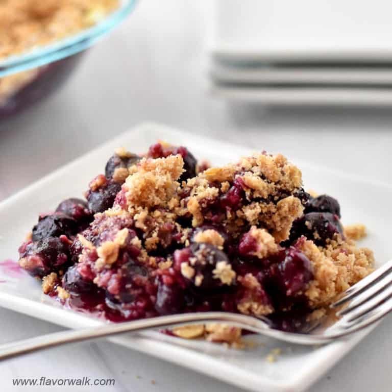 Gluten free blueberry crisp and fork on small white plate.