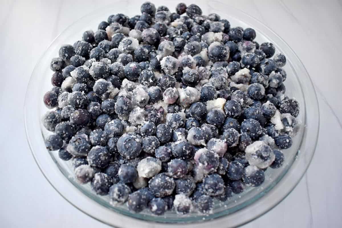 Blueberry crisp filling in pie dish.
