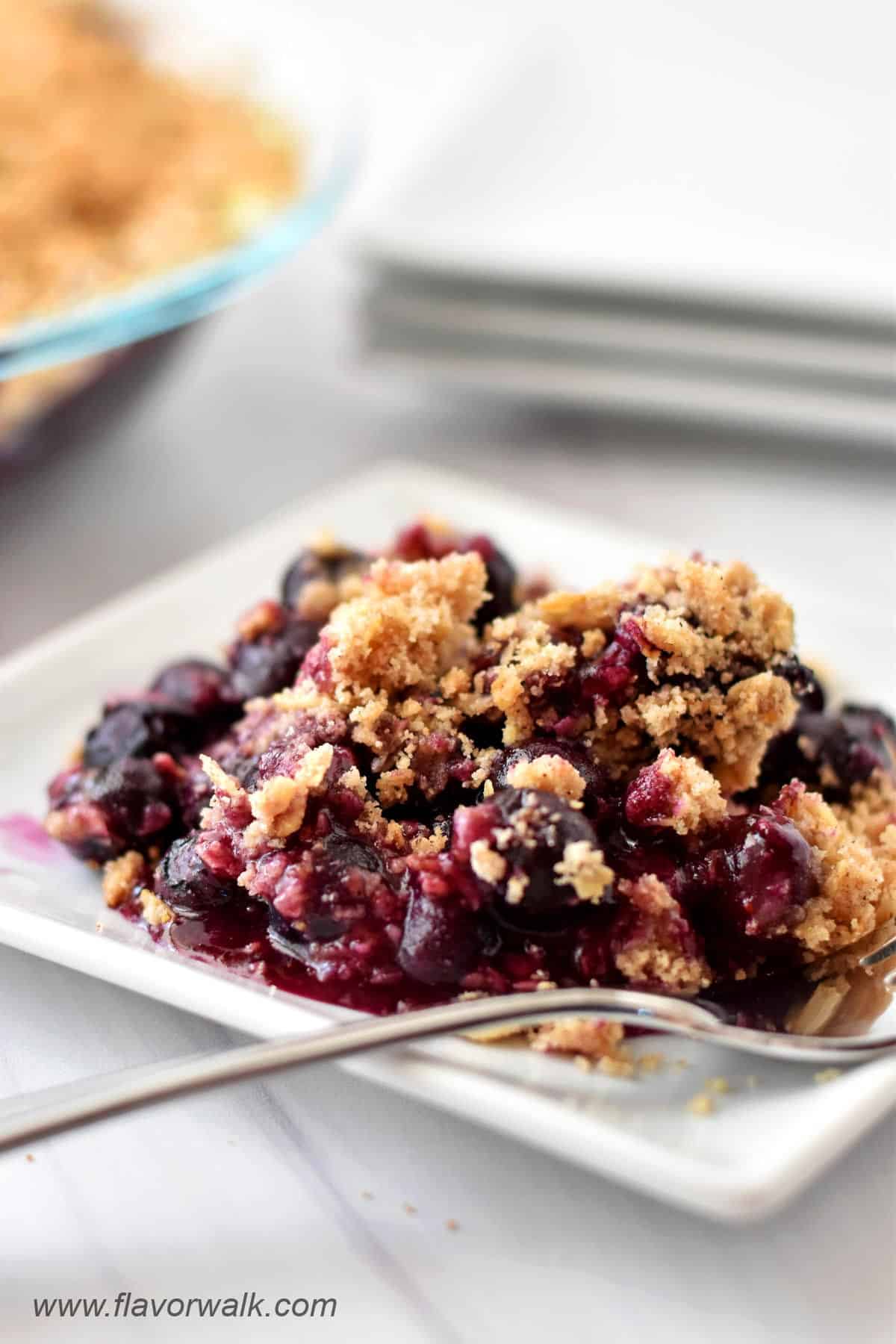 Gluten free blueberry crisp on a small white plate.