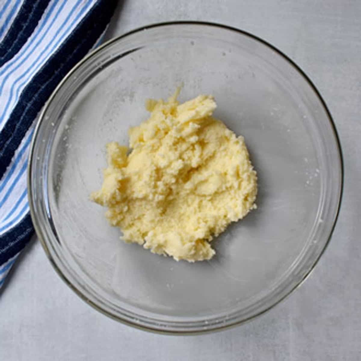Butter and sugar creamed together in glass mixing bowl.
