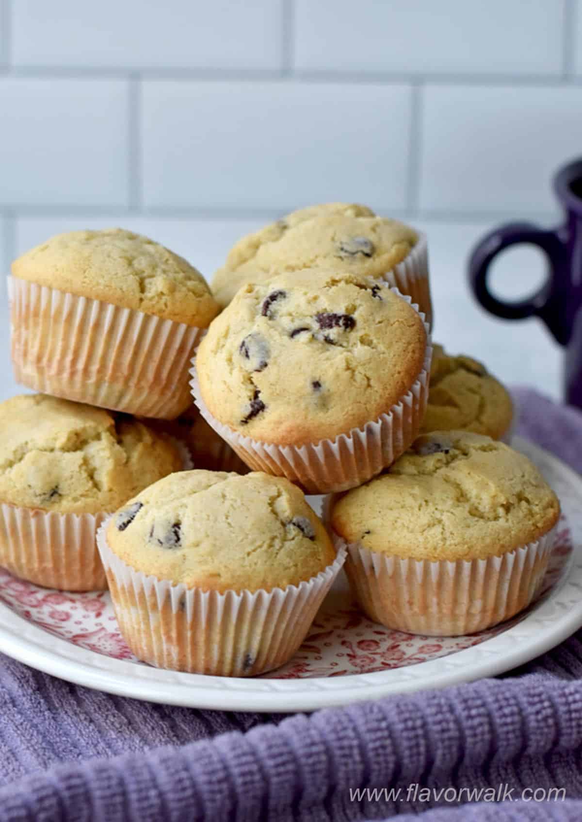 Gluten free chocolate chip muffins stacked on a round plate.