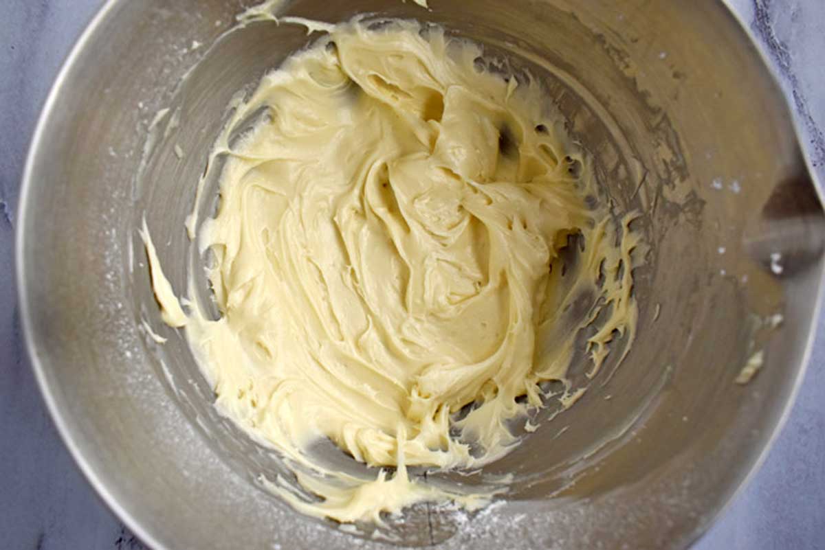 Cream cheese frosting in metal mixing bowl.
