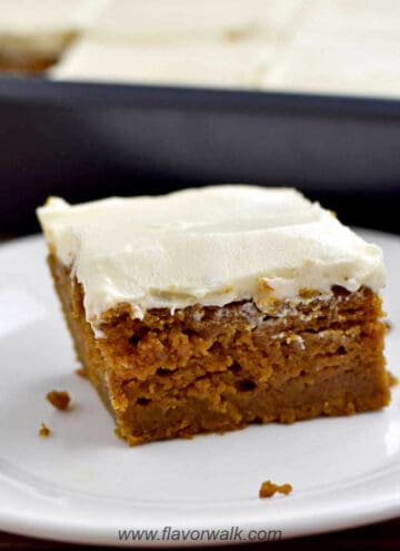 A gluten free pumpkin bar on a white plate with the remaining bars in the background.