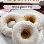 Three gluten free pumpkin donuts on a white plate with text overlay, "Pumpkin Donuts, Easy & Gluten Free."