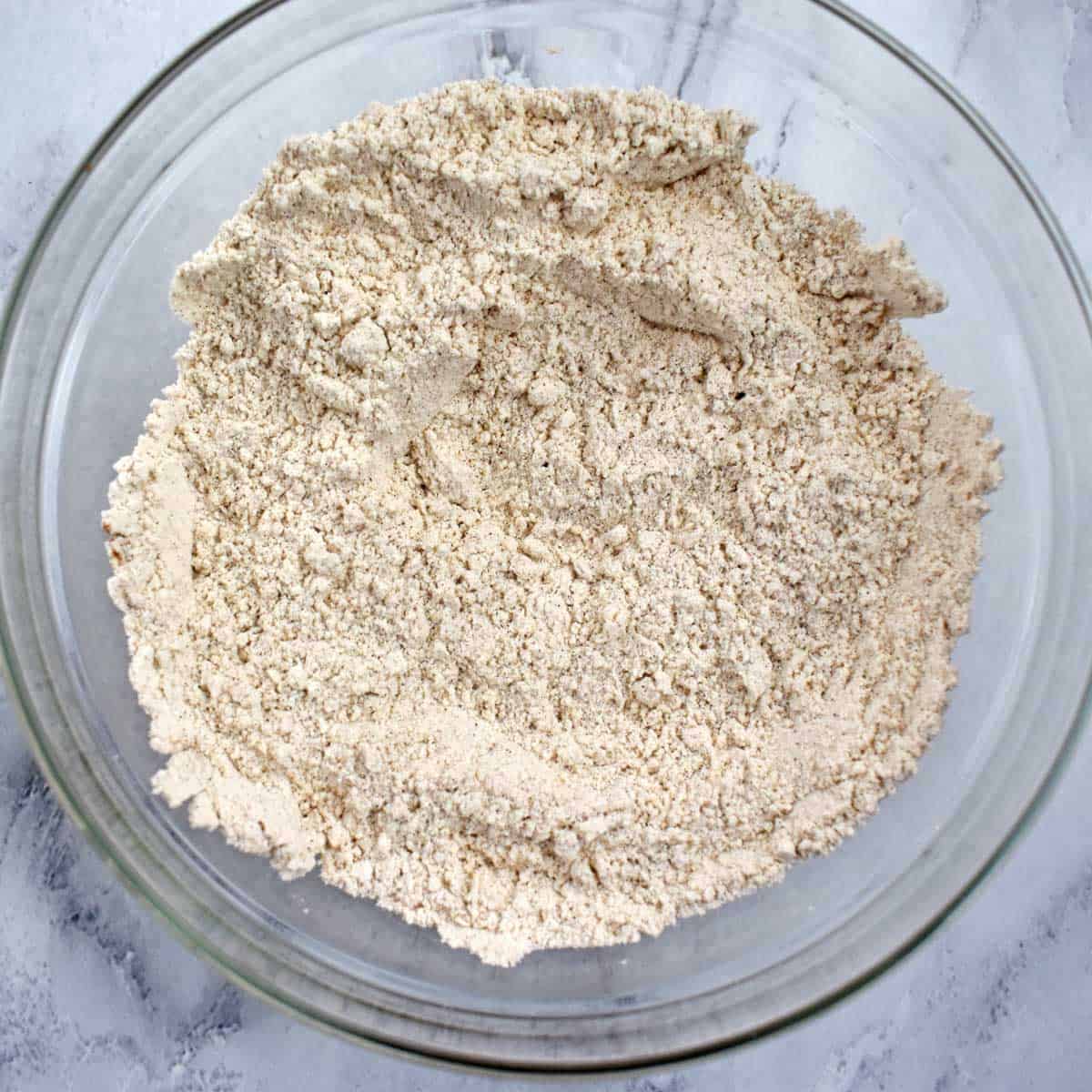 Gluten free flour, baking soda, salt, and spices whisked together in glass mixing bowl.