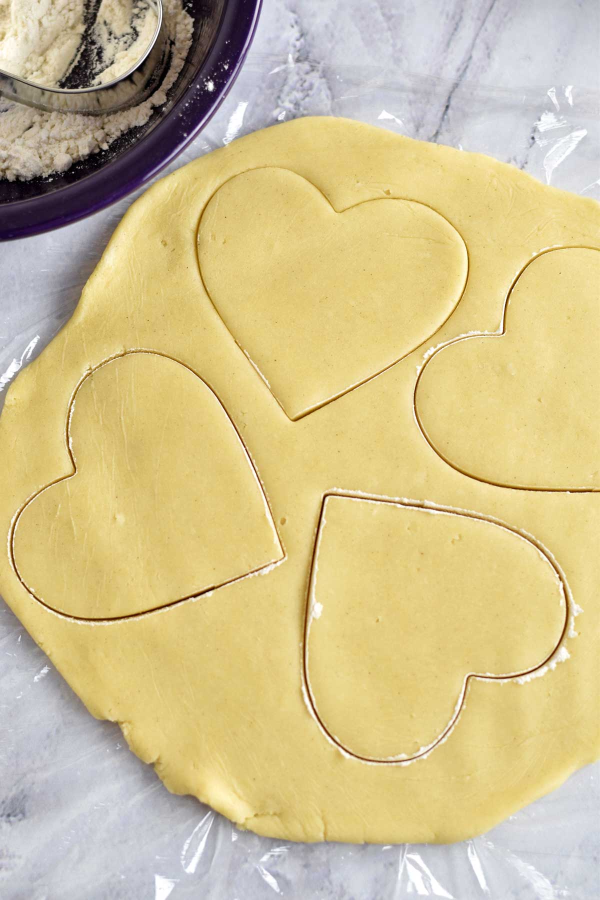 Gluten free sugar cookie dough with heart-shaped cut outs.