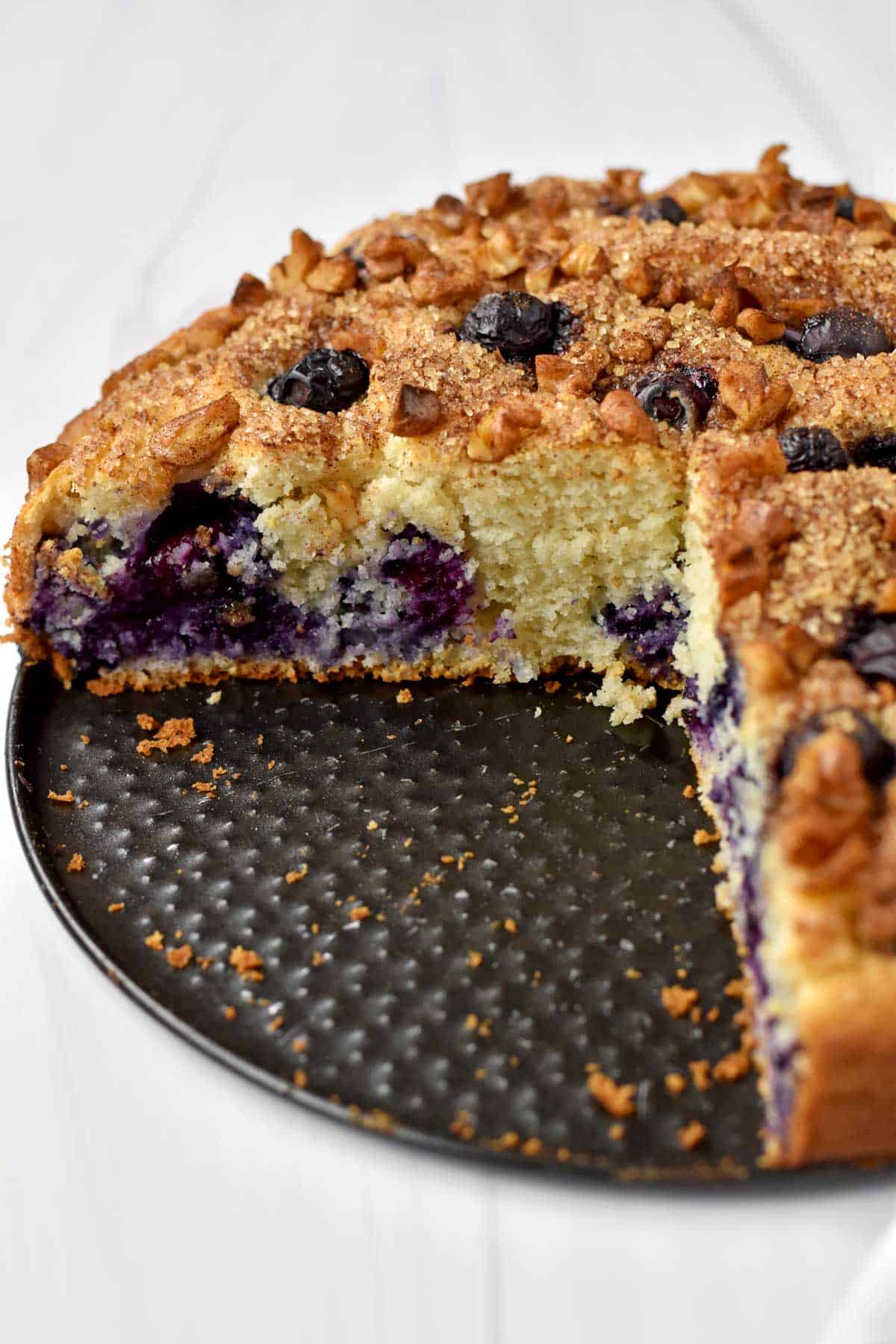 Gluten free blueberry cake with two slices removed from pan.