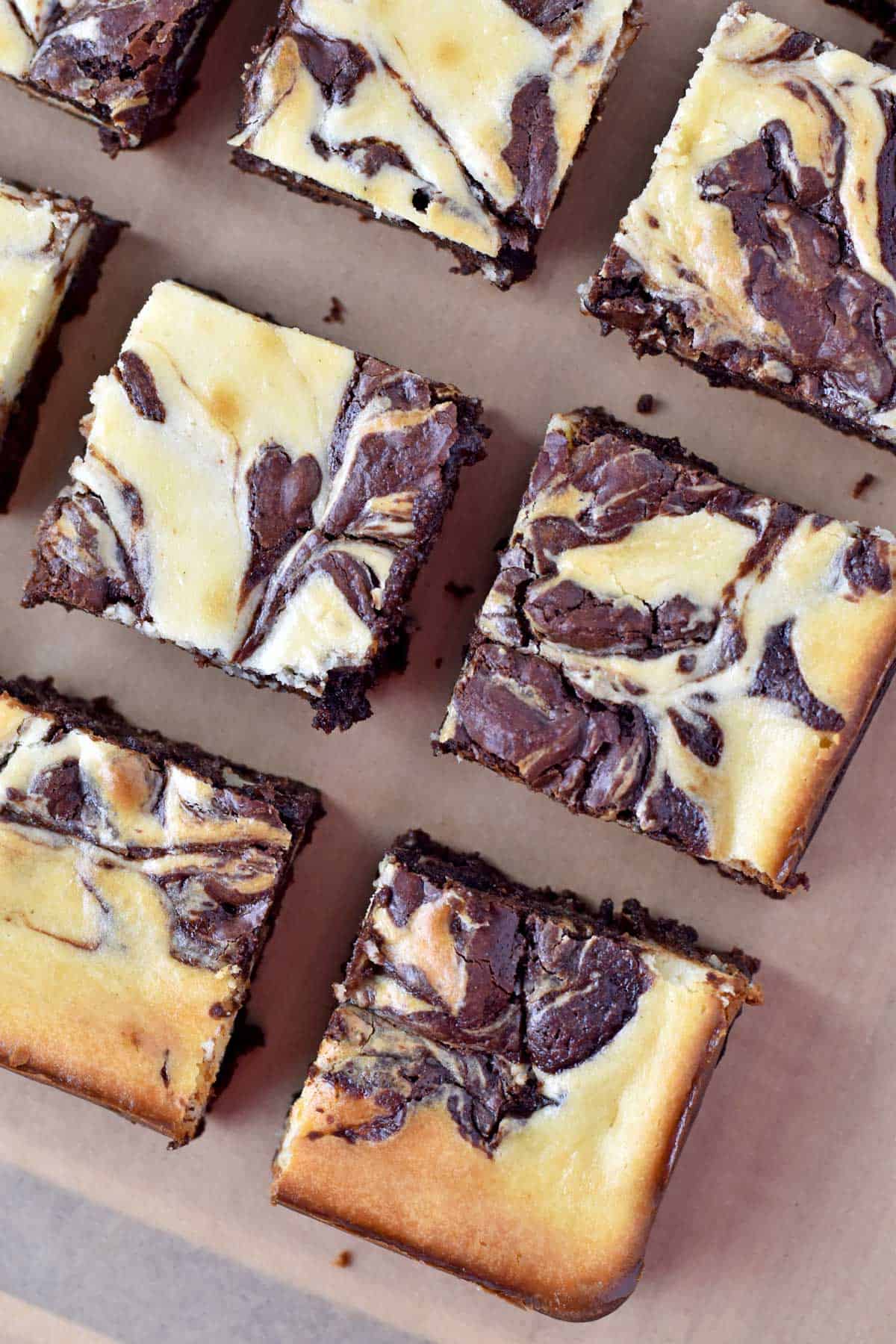 Overhead view of gluten free cheesecake brownies on parchment paper.