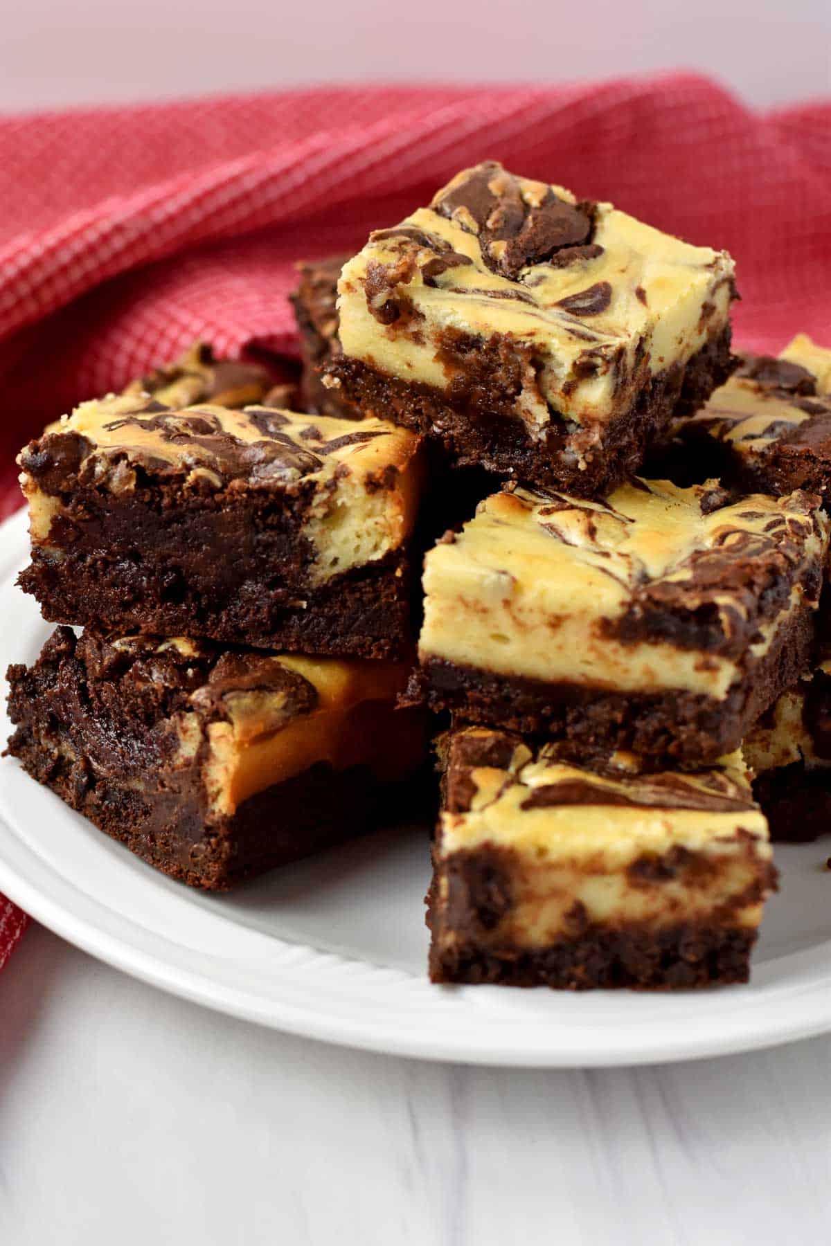 Tabletop view of a stack of gluten free cheesecake brownies.